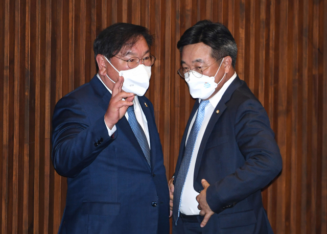 더불어민주당 윤호중 원내대표 겸 비상대책위원장(오른쪽)과 김태년 전 원내대표가 19일 국회 본회의에서 대화하고 있다. 연합뉴스
