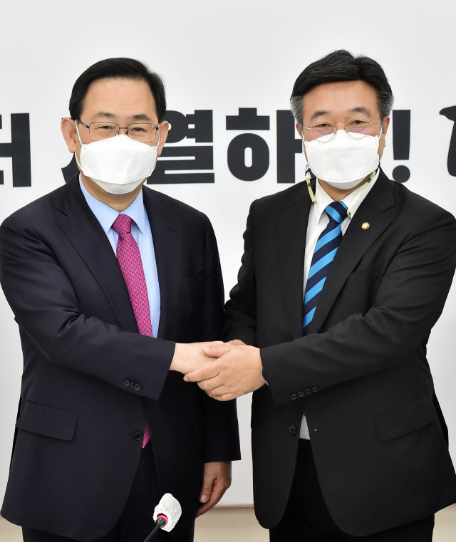 더불어민주당 윤호중 원내대표 겸 비상대책위원장(오른쪽)이 22일 서울 여의도 국회에서 국민의힘 주호영 당 대표 권한대행을 예방해 악수하고 있다. 연합뉴스