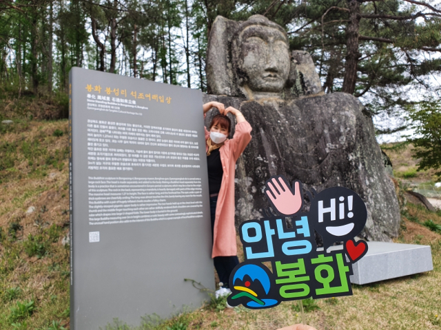 봉화 봉성리 석조여래입상을 찾은 관광객이 여행토퍼 앞에서 인증샷을 하고 있다. 봉화군 제공