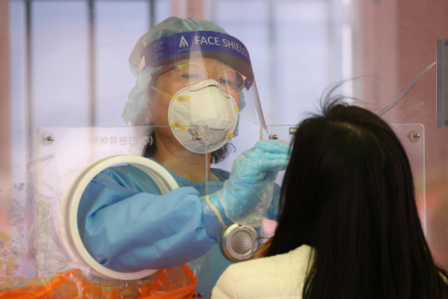 25일 오전 서울역광장에 마련된 코로나19 임시선별검사소에서 의료진이 검체 채취를 하고 있다. 중앙방역대책본부에 따르면 이날 0시 기준 코로나19 신규 확진자 수는 644명을 기록했다. 지날 20일 이후 닷새 만에 700명 아래로 신규 확진자 수가 줄었지만, 이는 평일 대비 주말 검사 건수가 대폭 줄어든 영향에 따른 것으로 추정돼 확산세가 꺾인 것으로 보기는 어려운 상황이다. 연합뉴스