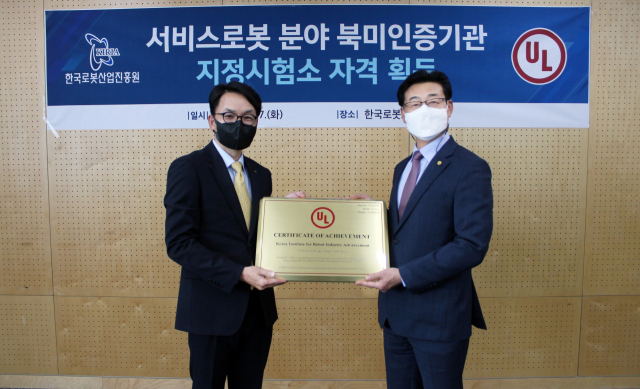 손웅희(오른쪽) 로봇산업진흥원장과 김광태 UL코리아 전무가 지정시험소 현판을 들고 있다. 한국로봇산업진흥원 제공