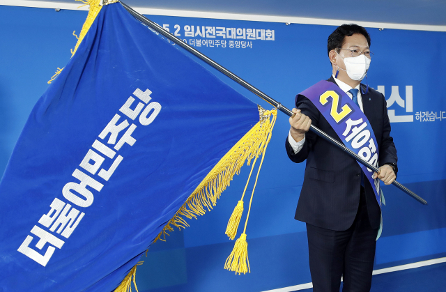 더불어민주당 새 대표로 선출된 송영길 의원이 2일 서울 여의도 중앙당사에서 열린 임시전국대의원대회에서 당기를 흔들어 보이고 있다. 연합뉴스