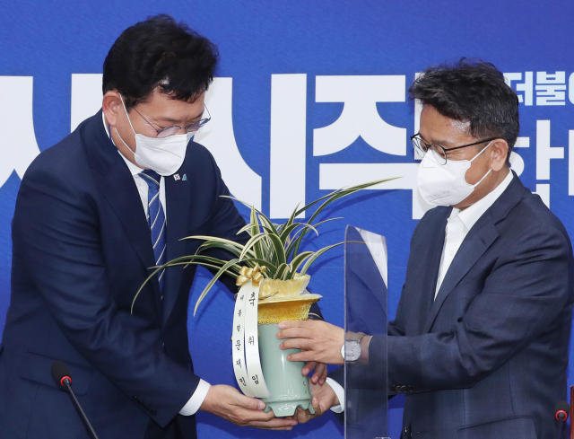더불어민주당 송영길 새 대표(왼쪽)가 3일 서울 여의도 국회에서 이철희 청와대 정무수석으로 부터 문재인 대통령의 축하난을 전달받고 있다. 연합뉴스