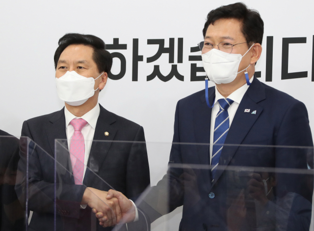 더불어민주당 송영길 새 대표(오른쪽)가 3일 서울 여의도 국회에서 국민의힘 김기현 당대표 권한대행 겸 원내대표를 예방해 악수하며 기념촬영을 하고 있다. 연합뉴스