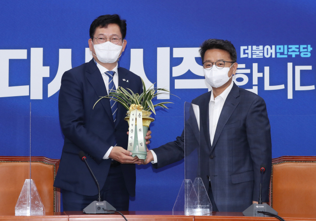 더불어민주당 송영길 새 대표(왼쪽)가 3일 서울 여의도 국회에서 이철희 청와대 정무수석으로 부터 문재인 대통령의 축하난을 전달받고 있다. 연합뉴스