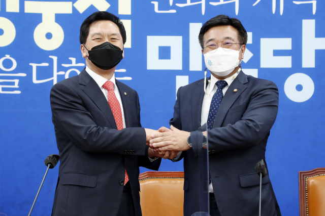더불어민주당 윤호중 원내대표(오른쪽)와 국민의힘 김기현 원내대표가 4일 서울 여의도 국회에서 손을 잡으며 인사를 나누고 있다. 연합뉴스