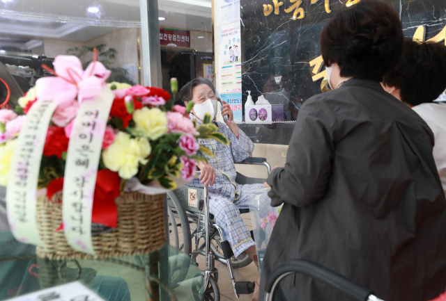 어버이날을 하루 앞둔 7일 부산 중구 중앙나라요양병원에서 이순애(97)씨가 두 딸 양정임(55), 양인숙(61)씨와 비접촉 면회를 하고 있다. 두딸은 