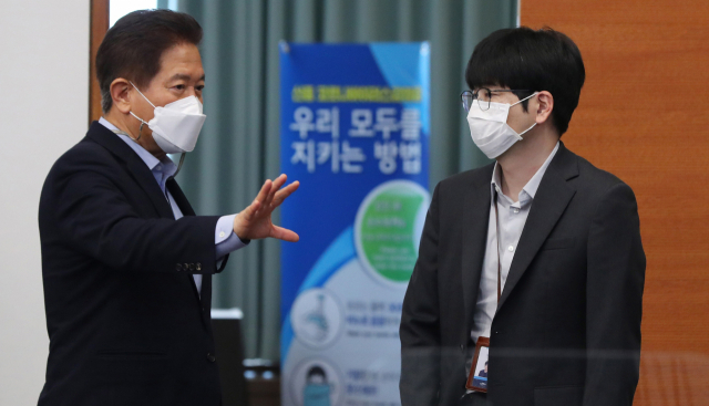 서주석(왼쪽) 국가안보실 1차장과 탁현민 의전비서관이(오른쪽)이 지난해 5월 청와대 수석·보좌관회의에서 만나 대화하고 있다. 연합뉴스
