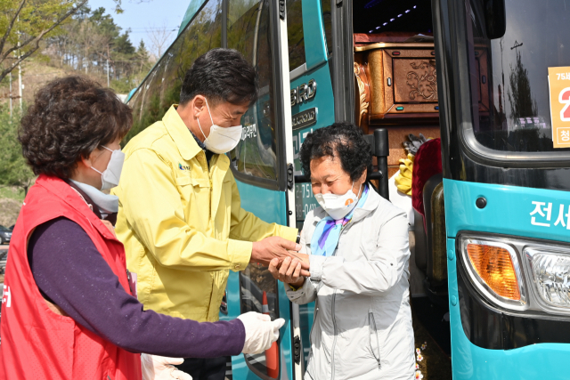 경북 청송군이 지난 6일부터 75세 이상 어르신들을 대상으로 시작한 코로나19 백신 2차 예방접종이 순조롭게 진행되고 있다. 셔틀버스에서 내리는 주민을 윤경희 청송군수가 접종센터로 인솔하고 있다. 청송군 제공