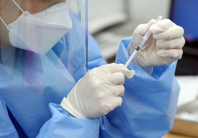 이달 말부터 신종 코로나바이러스 감염증(코로나19) 백신을 맞게 될 70세 이상 어르신의 사전 접종 예약이 순조롭게 진행되고 있다. 13일 코로나19 예방접종대응추진단에 따르면 지난 6일부터 사전 예약이 진행된 70∼74세 어르신의 접종 예약률은 이날 0시 기준 51.6%로 집계됐다. 전날(46.9%)보다 4.7%포인트(p) 높아졌다. 또 지난 10일부터 예약을 접수한 65∼69세의 예약률은 38.4%로, 전날 31.3%보다 7.1%p 올랐다. 사진은 이날 서울 동대문구 체육관에 마련된 코로나19 동대문구 예방접종센터에서 접종을 준비하는 의료진. 연합뉴스