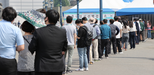 신종 코로나바이러스 감염증(코로나19) 신규 확진자가 연이틀 700명대를 기록한 14일 오전 서울시 중구 서울역 코로나19 선별검사소에 시민들이 검사를 받기 위해 줄을 서 있다. 연합뉴스