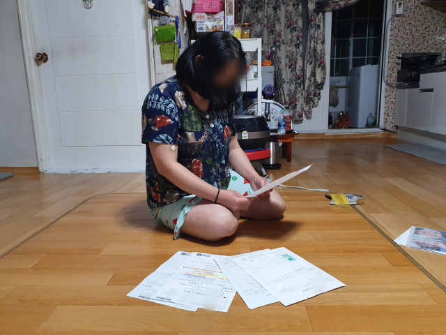 박정애(가명·48) 씨가 딸 아이의 진단서를 살펴보고 있다. 배주현 기자
