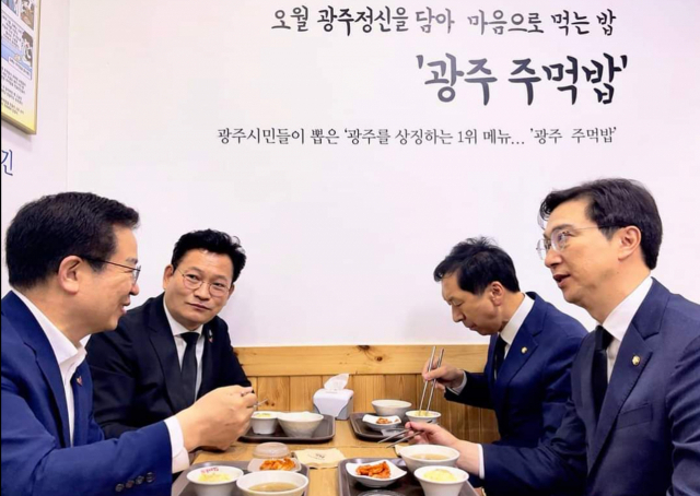 더불어민주당 송영길 대표(왼쪽 두 번째)와 국민의힘 김기현 대표 권한대행 겸 원내대표(오른쪽 두 번째)가 18일 5·18민주화운동 제41주년 기념식에 참석하기에 앞서 광주 한 식당에서 상생과 협력의 상징인 주먹밥을 먹으며 대화하고 있다. 연합뉴스