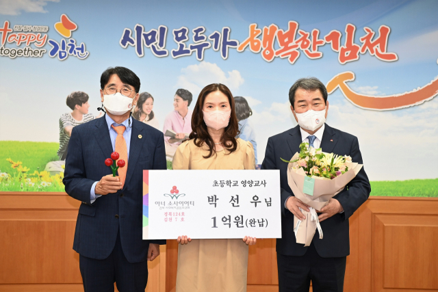 박선우 초등학교 영양교사가 24일 김천 7호로 아너소사이어티에 가입하며 기념촬영을 하고 있다. 왼쪽부터 전우헌 경북사회복지공동모금회장, 박선우 아너, 김충섭 김천시장. 경북모금회 제공