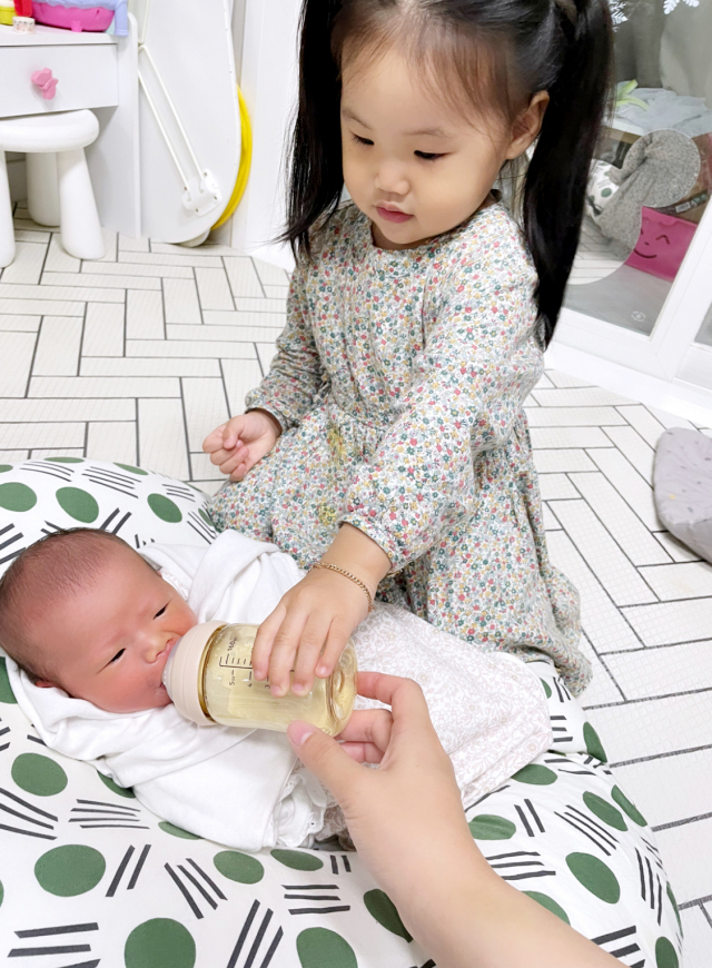 김진아·조성화 부부의 첫째 딸 조연주(3세) 양이 동생 유주에게 분유를 먹이고 있다.