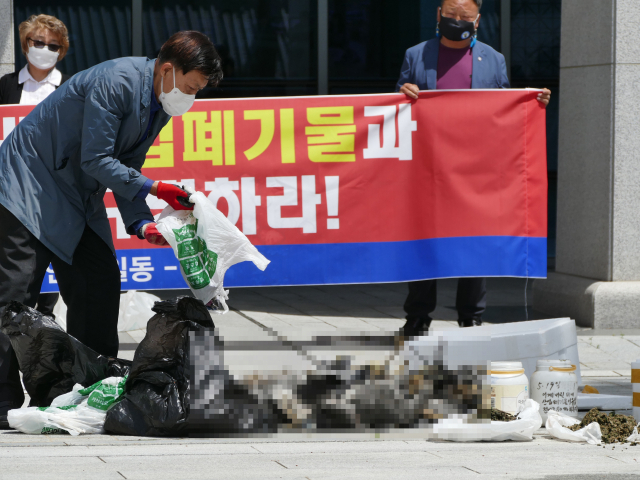 이태규 낙동강사랑환경보존회장이 25일 경북도청 앞에서 안동호 일원에서 폐사한 철새 사체와 수거된 폐미를 보여주는 퍼포먼스를 펼치고 있다. 김영진 기자