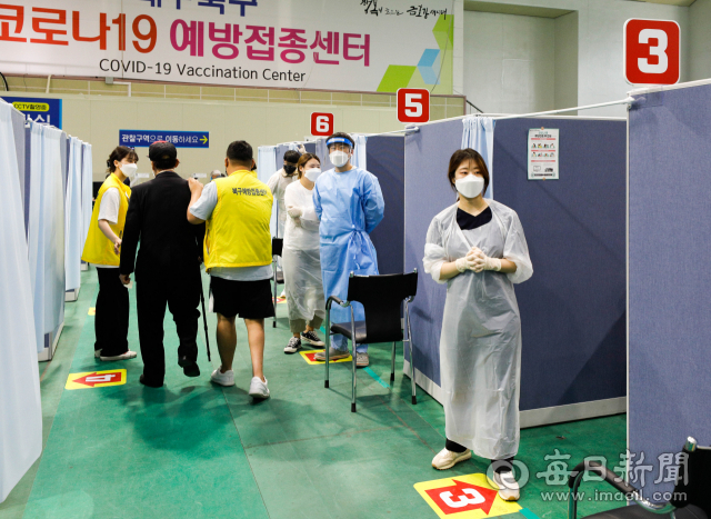 26일 오후 대구 시민체육관에 마련된 북구 예방접종센터에서 의료진과 봉사자들이 화이자 1차 백신 접종을 받으러 온 어르신들을 접종실로 안내하고 있다. 대구시는 75세 이상 어르신 미접종자 6만명에 대한 화이자 백신접종을 6월 말까지 완료할 예정이다. 우태욱 기자 woo@imaeil.com