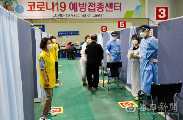 26일 오후 대구 시민체육관에 마련된 북구 예방접종센터에서 의료진과 봉사자들이 화이자 1차 백신 접종을 받으러 온 어르신들을 접종실로 안내하고 있다. 대구시는 75세 이상 어르신 미접종자 6만명에 대한 화이자 백신접종을 6월 말까지 완료할 예정이다. 우태욱 기자 woo@imaeil.com