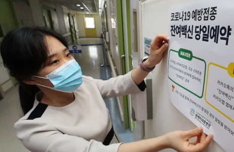 네이버와 카카오 앱을 이용해 신종 코로나 바이러스감염증(코로나19) 잔여 백신 조회와 예약이 가능해진 27일 오후 세종시의 한 종합병원에서 관계자가 관련 안내문을 붙이고 있다. 병원측은 이날 2명의 시민이 잔여 백신