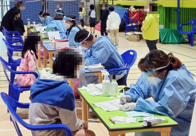28일 충남 서천군 장항중앙초등학교에 마련된 선별진료소에서 학생들이 신종 코로나바이러스 감염증(코로나19) 검사를 받고 있다. 서천군은 이 학교 씨름 교육 프로그램에 강사로 나선 A씨(서천 92번)가 전날 코로나19 확진 판정을 받은 데 이어 씨름을 배운 학생 2명(서천 94∼95번)이 확진되자, 이날 교내에 선별진료소를 설치하고 재학생과 교직원 등 260명을 대상으로 코로나19 검사를 했다. 연합뉴스