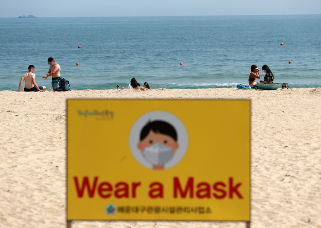 31일 오후 부산 해운대해수욕장에서 외국인들과 시민들이 더위를 피하고 있다. 부산지역 7개 공설해수욕장 중 해운대와 송정 해수욕장이 다음달 1일부터 일부 구간 조기 개장한다. 조기 개장 기간에는 코로나19 상황을 고려해 파라솔과 튜브 등은 대여가 불가능하다. 연합뉴스