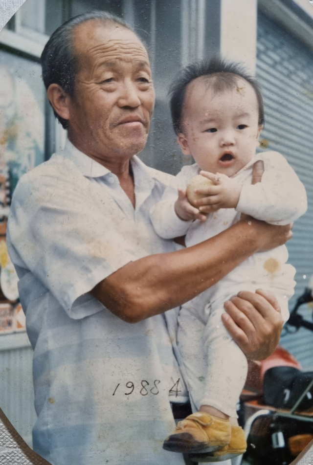 1988년 4월 故 박노덕 씨가 손자 박창호 씨를 안고 있는 사진. 가족제공.