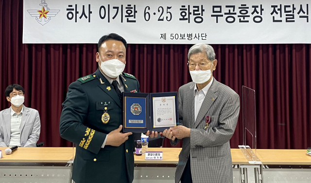 50사단 전성근 동구대대장(중령,왼쪽)이 이기환 참전용사(오른쪽)에게 화랑무공훈장(훈장증)을 수여하고 있다. 육군 제50보병사단 제공