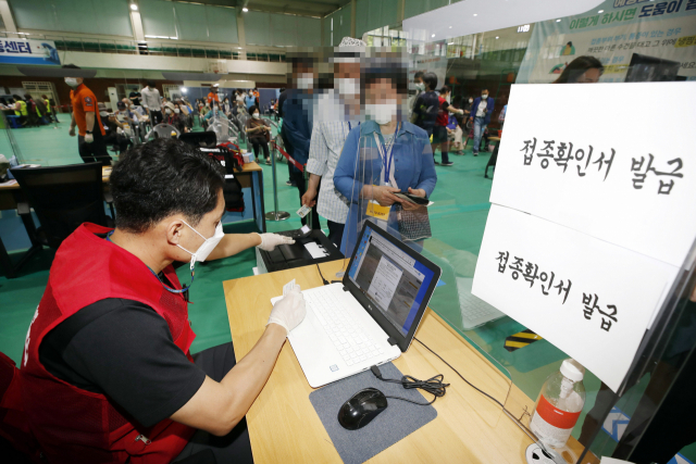 2일 오후 광주 북구 코로나19 백신 예방접종센터에서 직원이 접종을 완료자들에게 예방접종확인서를 발급해주고 있다. 접종 완료자들을 대상으로 경로당과 복지관 등 노인시설을 이용할 수 있는 백신 접종 인센티브 제도가 시행됨에 따라 예방접종 확인서를 발급받는 접종자들이 늘어나고 있다. 연합뉴스