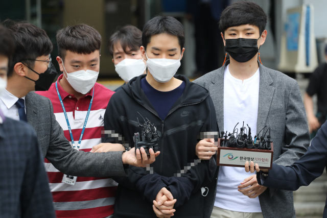 음란영상 판매 피의자 김영준이 지난해 6월 11일 검찰로 가기위해 종로경찰서에서 나오고 있다. 김씨는 여성행세를 하며 영상 통화로 촬영한 남성들의 알몸 사진 등을 인터넷에 유포한 혐의다. 경찰은 지난 9일 김씨의 신상을 공개했다. 연합뉴스