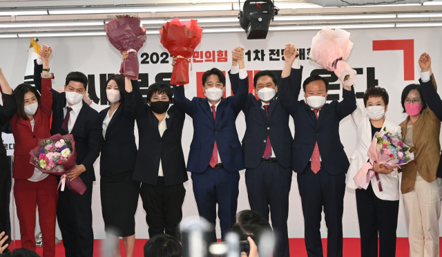 국민의힘 이준석 새 대표와 최고위원 등이 11일 서울 여의도 중앙당사에서 열린 전당대회에서 함께 손을 잡고 기뻐하고 있다. 오른쪽 세번째 부터 김재원 최고위원, 김기현 원내대표, 이준석 대표, 조수진, 배현진 최고위원. 연합뉴스
