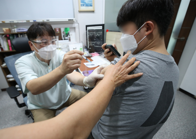 30세 이상 예비군 등에 대한 얀센 백신 접종이 시작된 10일 서울 동작구 경성의원에서 한 시민이 얀센 백신을 접종받으며 휴대전화로 인증샷을 찍고 있다. 백신 1차 접종자는 이날 오전 11시 기준 1천6만705명으로 집계됐다. 지난 2월 26일 첫 접종이 시작된 지 105일째 되는 날 누적 1천만 명을 넘어섰다. 연합뉴스