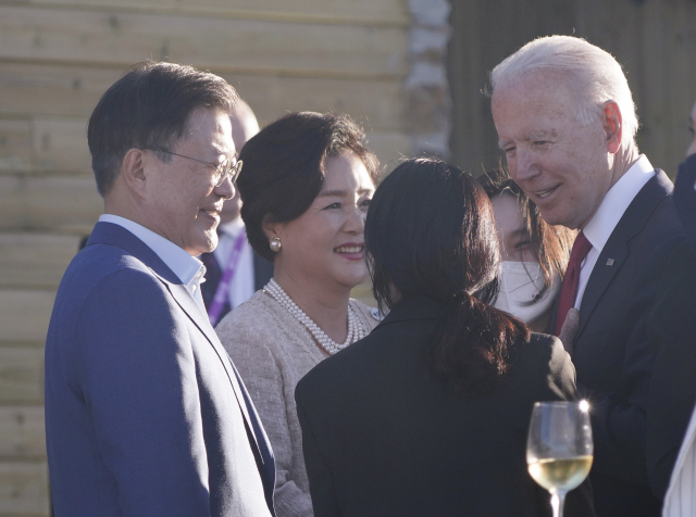 G7 정상회의에 참석 중인 문재인 대통령 부부와 조 바이든 미국 대통령이 12일 오후(현지시간) 영국 콘월 카비스베이 호텔 앞 해변에 마련된 만찬장에서 에어쇼를 기다리며 환담을 나누고 있다. 연합뉴스