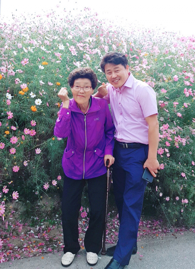김일 씨와 모친 강근순 씨가 활짝핀 코스모스 앞에서 함께 찍은 기념 사진. 가족제공.