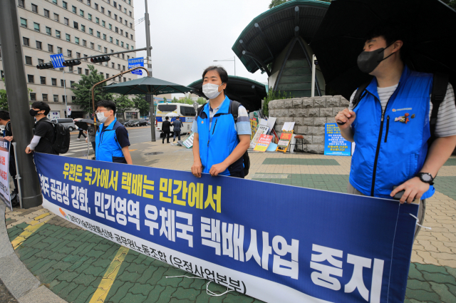 우정사업본부 공무원노조원들이 18일 서울 여의도 국회 앞에서 우체국 공공성 강화와 민간영역 우체국 택배사업 중지 등을 촉구하고 있다. 연합뉴스