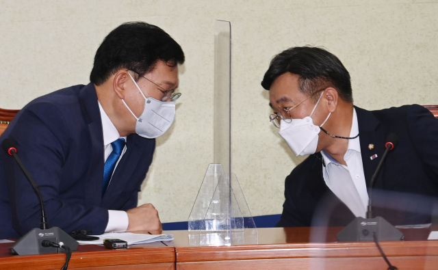 더불어민주당 송영길 대표(왼쪽)와 윤호중 원내대표가 18일 서울 여의도 국회에서 열린 최고위원회의에서 대화하고 있다. 연합뉴스