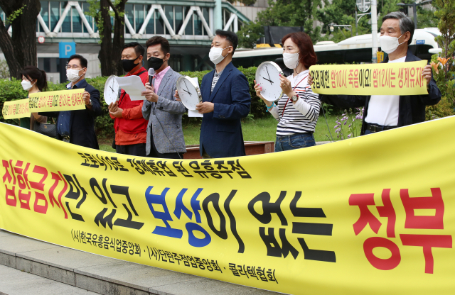 한국유흥음식중앙회, 단란주점업중앙회·콜라텍협회 관계자들이 18일 오후 서울 종로구 세종공원에서 코로나19로 인한 영업시간 제한 조치 해제 기자회견을 하고 있다. 연합뉴스