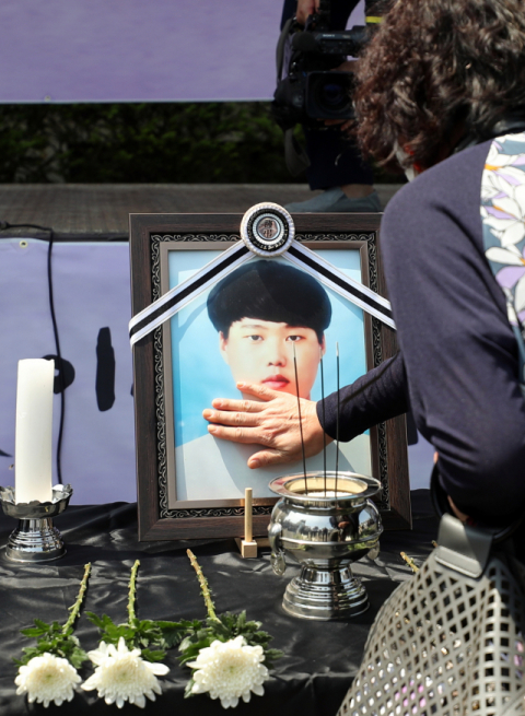 19일 오전 경기 평택시 안중백병원 장례식장에서 열린 평택항 청년 노동자 고(故) 이선호 씨의 시민장(葬)에서 이 씨의 친척이 영정사진을 어루만지고 있다. 연합뉴스