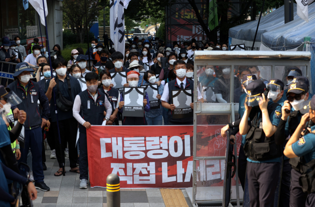 19일 오후 서울 중구 고용노동청 앞에서 민주노총 주최로 열린 중대재해 노동자 합동추모제에서 산재로 사망한 노동자 344개 영정을 들고 청와대 방향으로 행진하려던 참가자들이 경찰과 대치를 하고 있다. 신종 코로나바이러스 감염증(코로나19)로 인해 서울 시내 10인 이상 집회가 금지되면서 경찰이 펜스와 경찰버스로 무대 주위를 둘러싸고 집회 참가자들의 출입을 막아 충돌이 빚어졌다. 연합뉴스