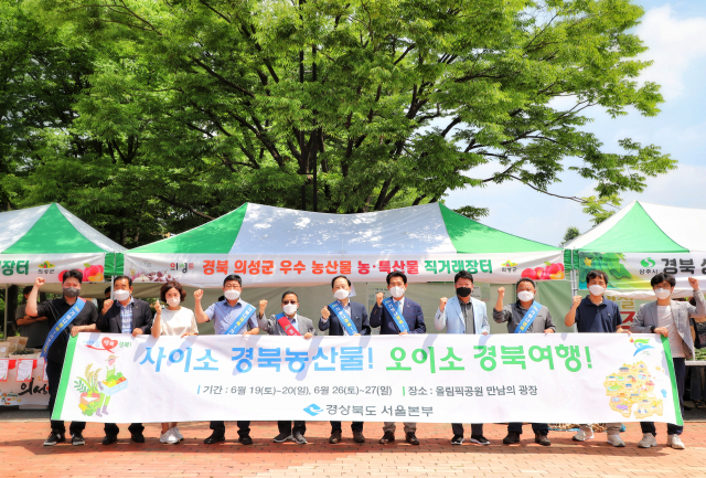 서울 올림픽공원 만남의 광장에 마련된 경북 농산물 직거래 장터 앞에서 관계자들이 기념촬영을 하고 있다. 경북도 제공