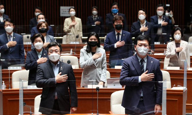 더불어민주당 송영길 대표와 윤호중 원내대표를 비롯한 의원들이 22일 오전 서울 여의도 국회에서 열린 의원총회에서 국기에 대한 경례를 하고 있다. 연합뉴스