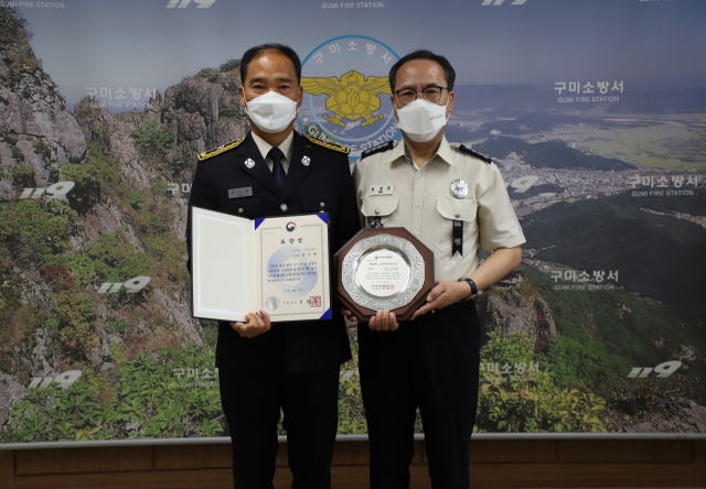 경북 구미소방서 정석대(왼쪽) 소방관이 23일 소방안전봉사상 본상을 수상해 한상일 구미소방서장과 함께 기념촬영을 했다. 구미소방서 제공