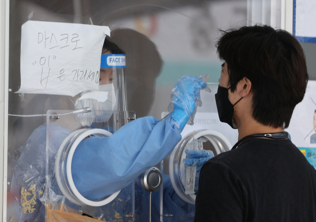 25일 오후 서울 중구 서울역 광장에 마련된 중구임시선별검사소에서 한 시민이 신종 코로나바이러스 감염증(코로나19) 선별검사를 받고 있다. 연합뉴스
