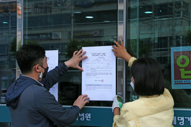 23일 경북 포항 세명기독병원 앞에서 포항시 관계자가 병원 일시 폐쇄를 알리는 안내문을 붙이고 있다. 이 병원에서는 지난 21일부터 신종 코로나바이러스 감염증 확진자가 무더기로 발생했다. 연합뉴스