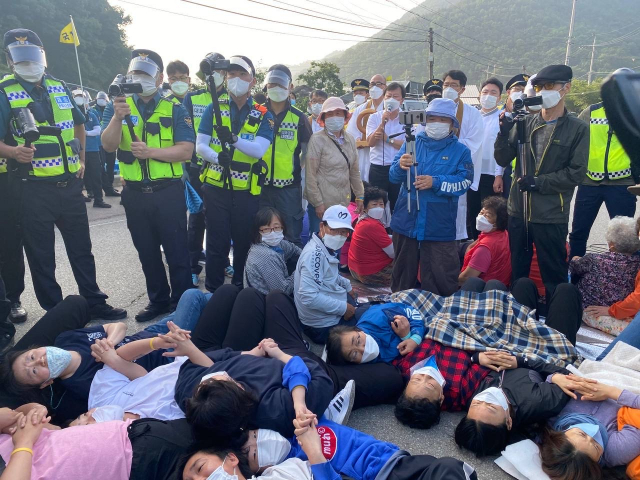 사드 반대 측 관계자들이 도로에 드러누워 차량 경찰 해산에 맞서고 있다. 사드철회 소성리종합상황실 제공