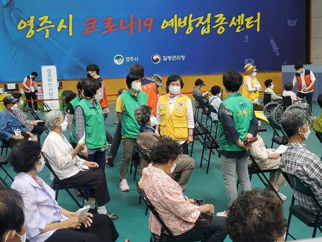 자원봉사자들이 어른신 예방 접종을 지원하고 있다. 마경대 기자