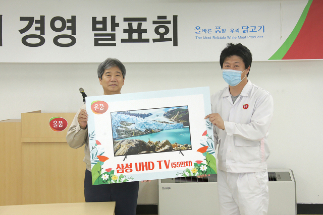 1일 올품 변부홍 대표이사(왼쪽)가 경품추첨에 당첨된 직원에게 해당 경품을 전달하고 있다. 올품 제공