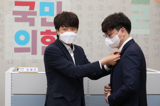 국민의힘 이준석 대표가 6일 오전 국회 당대표실에서 열린 신임 대변인단 티타임에서 신인규 상근부대변인에게 당 배지를 달아주고 있다. 연합뉴스