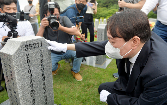 윤석열 전 검찰총장이 6일 오전 대전 유성구 국립대전현충원 천안함 46용사 묘역을 찾아 묘비를 어루만지고 있다. 연합뉴스