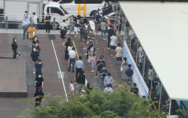 하루 신종 코로나바이러스 감염증(코로나19) 신규 확진자 수가 1천200명을 넘어선 7일 오전 서울시 성북구 임시 선별진료소에서 시민들이 검사를 위해 길게 줄지어 서 있다. 연합뉴스
