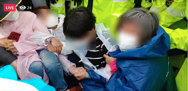 사드 반대 측 관계자들이 서로의 팔짱을 낀채 경찰 해산에 맞서고 있다. 사드철회 소성리종합상황실 제공